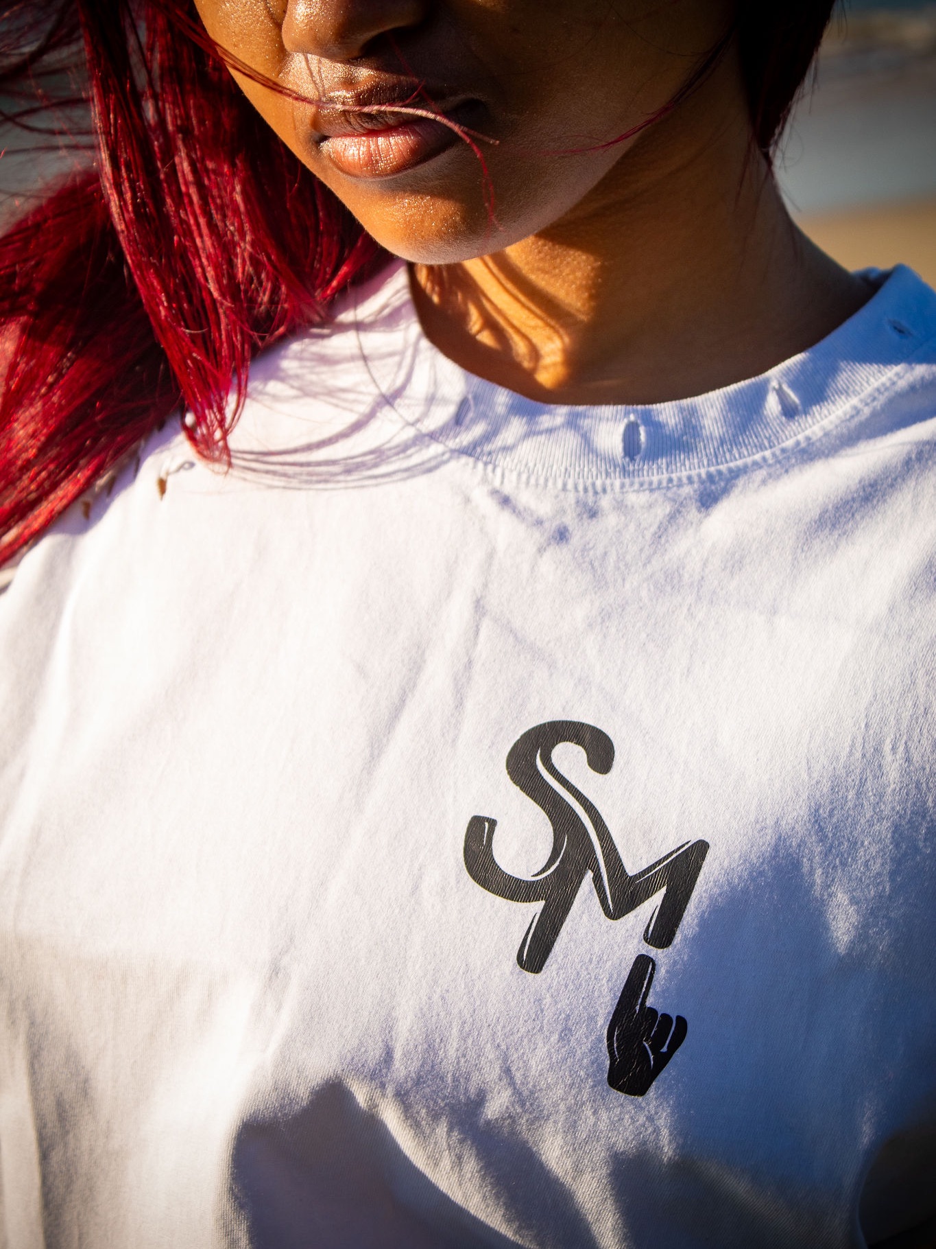 Close-up of the Sqedi Mandatory logo on a white tee